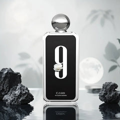 A rectangular perfume bottle with a large number nine and a white flower on a black label.