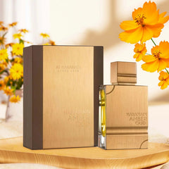 A bottle of Al Haramain Amber Oud Gold Edition perfume stands next to its matching gold box.