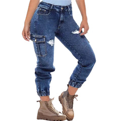 A woman wears distressed blue denim cargo jeans with elastic cuffs and side pockets.