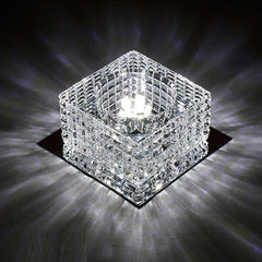 A square crystal ceiling light fixture with a reflective base casting light patterns.