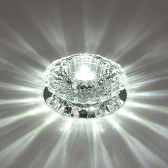 A modern crystal surface-mounted LED ceiling light casting a bright, starburst pattern of light.