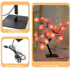 A rose tree lamp with glowing pink flowers, a black base, and a USB power cord.