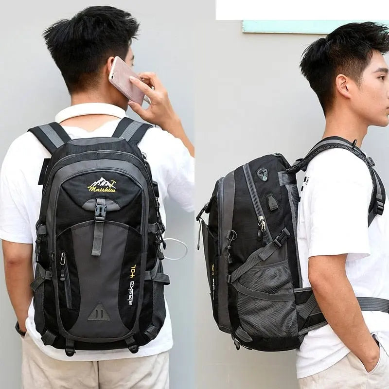 A young man in a white shirt models the Anti-theft Mountaineering Waterproof Backpack for men, a large-capacity outdoor bag with multiple compartments and straps, shown from back and side views while holding a phone to his ear.
