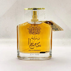 A clear glass bottle of Arabian Sandalwood atmospheric perfume, with amber liquid, gold Arabic script, a faceted cap, and decorative tag—exclusively for Middle East fragrance Dubai UAE royal men’s and women’s use.