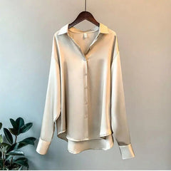 A long-sleeved, champagne-colored silk-look button-down shirt with a turn-down collar.