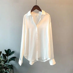 A long-sleeved white silk-style button-down shirt with a turn-down collar.