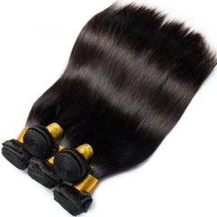 Four bundles of Bone Straight Human Hair Bundles, 30-inch Brazilian Remy Extensions in natural color, are neatly stacked and secured with gold bands. These silky bundles offer a sleek look, ideal for Black women.