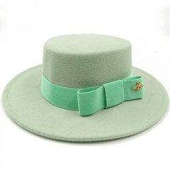 A light green felt fedora hat with a flat top and a matching ribbon bow featuring a gold bee pin.