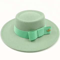 A mint green felt fedora hat with a matching ribbon bow and a small gold bee emblem.