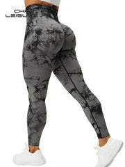 A woman wears grey and black tie-dye high-waisted seamless leggings with a booty-lifting design.