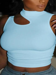 A woman wears the Chic Off-Shoulder Crop Top—a light blue sleeveless crop with a high neckline and cut-out detail—paired with blue jeans. Her long nails are multicolored.