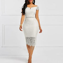 A woman in an Elegant Lace Evening Wedding Party Dress featuring a slim bodycon fit, cap sleeves, and a sheer lace hem poses by a white wall. She completes the look with gold heels, a bracelet, and loose waves.