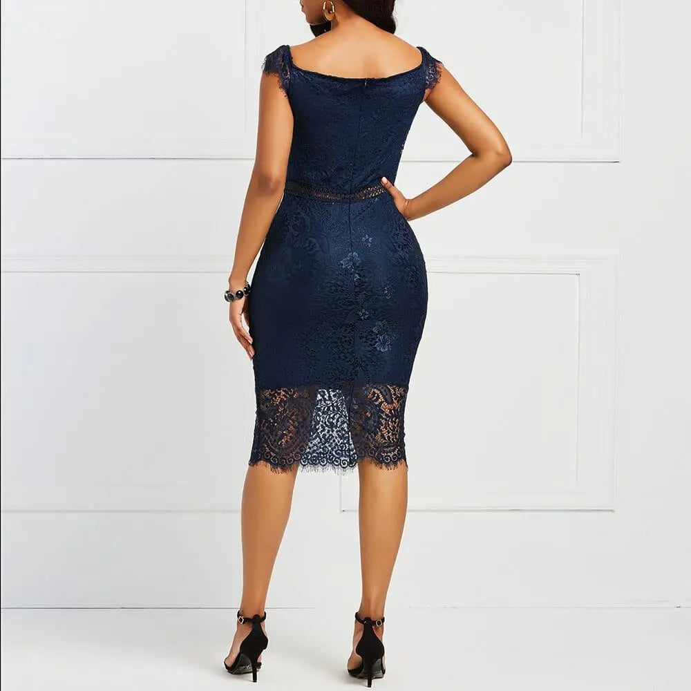 A woman stands with her back to the camera, wearing the Elegant Lace Evening Wedding Party Dress—navy blue, slim fit, cap sleeves, sheer lace hem—paired with black heels and a bracelet.
