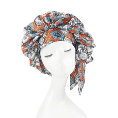 An extra large satin sleep bonnet featuring an orange and blue African floral print pattern.