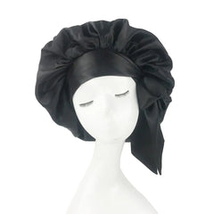 A solid black satin sleep bonnet with an adjustable wide band on a mannequin head.