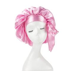 A pink satin bonnet with an adjustable wide band worn on a white mannequin head.