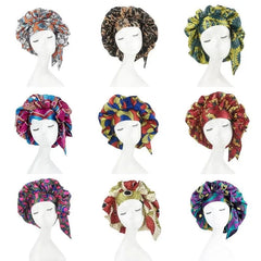 A grid of nine mannequin heads wearing satin bonnets in various colorful African print patterns.