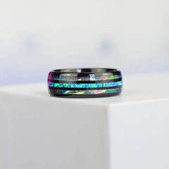 A black stainless steel ring featuring an inlay of blue opal and iridescent abalone shell.