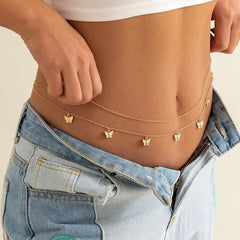 A person wears the Fashion Classic Cute Butterfly Waist Chain, a simple and sexy body jewelry piece for summer vacations, over bare skin with unbuttoned blue jeans and a white crop top. Small butterfly charms add a boho touch.