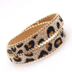 The Fashion Leopard Leather Bracelet for Women features a faux leopard print, double-layer wrap, and gold bead borders—an all-match, stylish wide cuff wristband perfect for modern fashion.