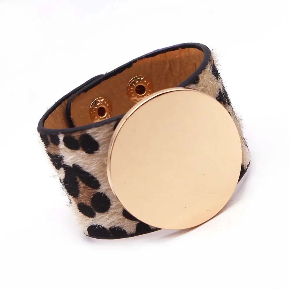 The Fashion Leopard Leather Bracelet for women features a wide leopard print band, bold gold V charm, and snap closures—an all-match, stylish cuff perfect as a statement wristband accessory.