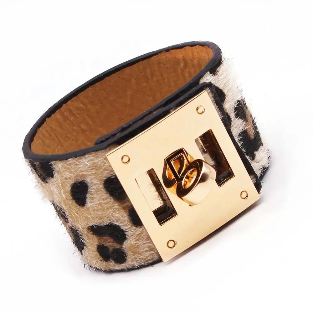 The Fashion Leopard Leather Bracelet for women is a wide cuff with a leopard print, gold-toned square clasp, and black edging. Its textured fur-like look makes this all-match V word charm wristband a stylish jewelry piece.