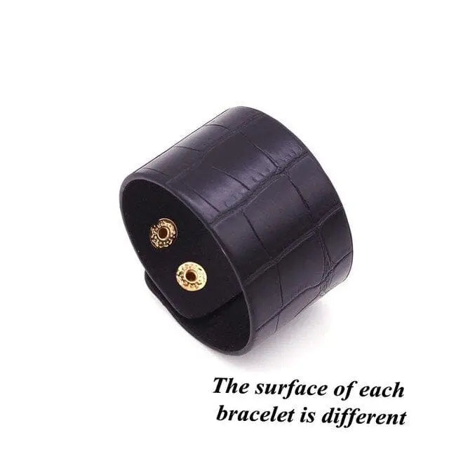 The Fashion Leopard Leather Bracelet for women features a wide, textured crocodile-style black leather band with two gold snap buttons—each has a unique surface texture and is displayed on a white background.