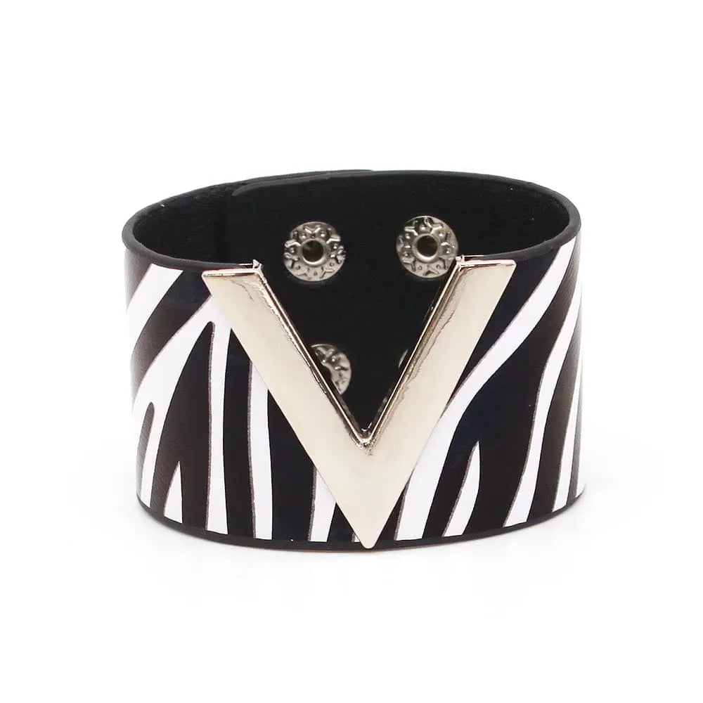 The Fashion Leopard Leather Bracelet for women features a wide black band with bold white zebra stripes and a large metallic V accent, secured by two snaps. This statement cuff is a striking, all-match accessory for any outfit.
