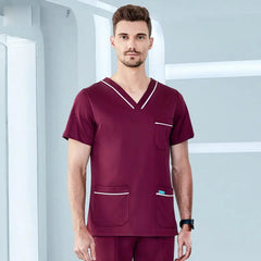 A man wears a burgundy V-neck medical scrub top with white trim on the collar and pockets.