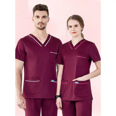 A man and a woman wearing matching burgundy V-neck medical scrub tops with contrasting trim.