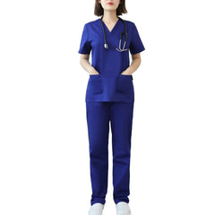 A woman wearing a dark blue V-neck scrub top and matching pants with a stethoscope.