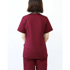 A woman seen from behind wearing a maroon short-sleeved scrub top and matching pants.