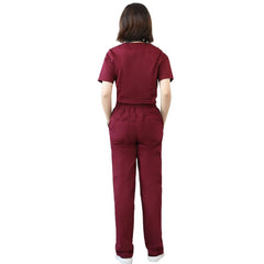 A woman seen from behind wearing a matching burgundy scrub top and elastic-waist pants.