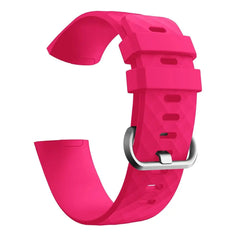 A bright pink silicone replacement watch band for a Fitbit Charge 3 with a silver buckle.