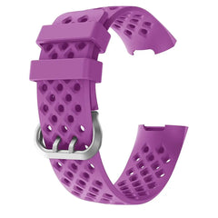 A purple silicone replacement watch strap for Fitbit Charge 3 with a breathable perforated design.