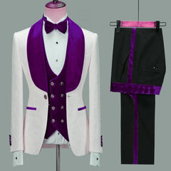 A slim-fit wedding tuxedo with a navy blue floral jacket and velvet lapel, matching vest, bow tie, and pocket accents; paired with black pants featuring side stripes and a contrasting waistband.