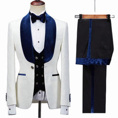 The Floral Jacket Men Suit features a slim fit white tuxedo with navy blue velvet lapels, matching bow tie, black double-breasted vest, and black pants with a velvet stripe—ideal for weddings or parties seeking elevated style.
