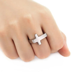 A polished stainless steel ring featuring a prominent cross design worn on a finger.