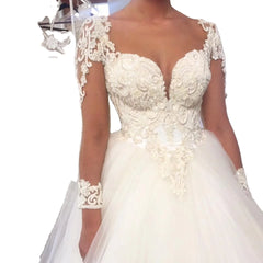A white ball gown wedding dress featuring a sweetheart neckline, lace embroidery, and long sleeves.