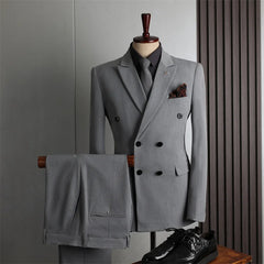 A grey double-breasted suit with a black shirt, tie, and pocket square displayed on a mannequin.
