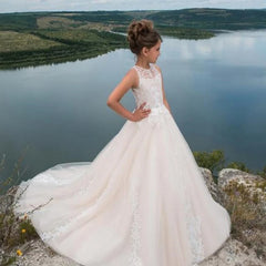 A girl wears a floor-length white ball gown with a lace bodice and beaded accents.