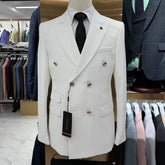 A white double-breasted slim fit men's suit jacket with gold buttons and a black tie.