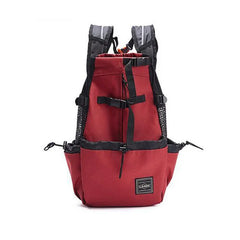 A red nylon pet carrier backpack with mesh side panels and adjustable straps.