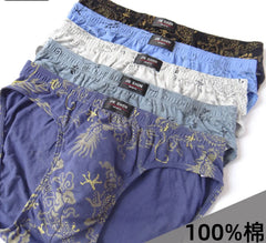 A stack of five men's cotton briefs in various colors featuring a dragon print pattern.