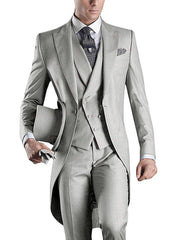 A man wearing a light gray three-piece slim fit tuxedo with a peaked lapel and top hat.