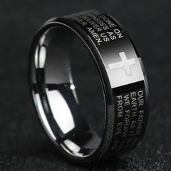 A black stainless steel ring featuring an engraved Christian cross and Bible verse text.