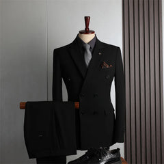 A black double-breasted suit with a grey shirt, tie, and pocket square displayed on a mannequin.