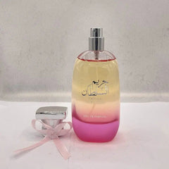 A bottle of Hareem Al Sultan perfume with a pink ombre base and a matching bow on the cap.
