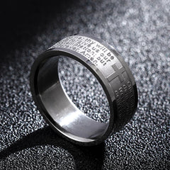 A silver-toned stainless steel ring engraved with the Lord's Prayer and a small cross.