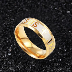 A gold-toned stainless steel ring featuring a textured band with engraved crosses and Jesus text.